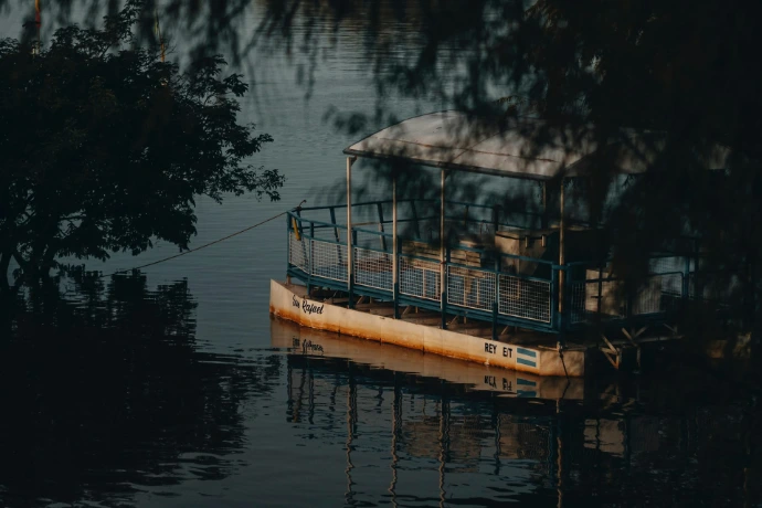 A boat rests calmly on the dark water.